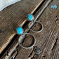 silver earrings with turquoise stones on a wooden surface