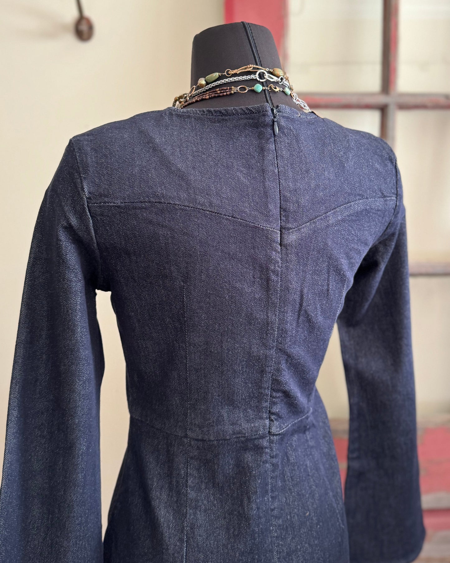 Blue denim dress on a mannequin against a neutral background