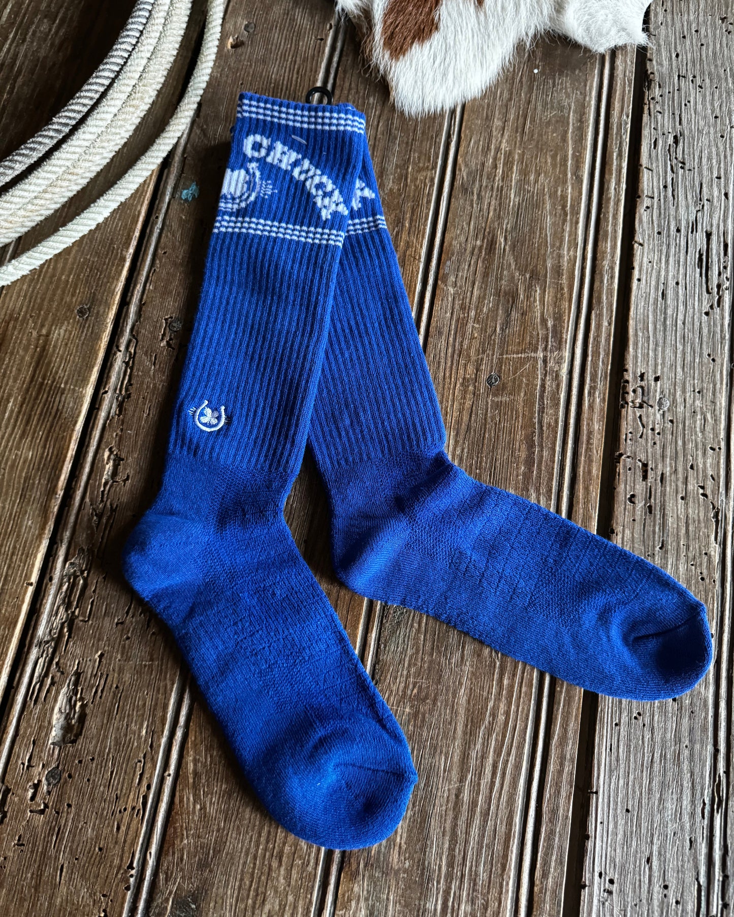 Blue socks with branding on a wooden surface