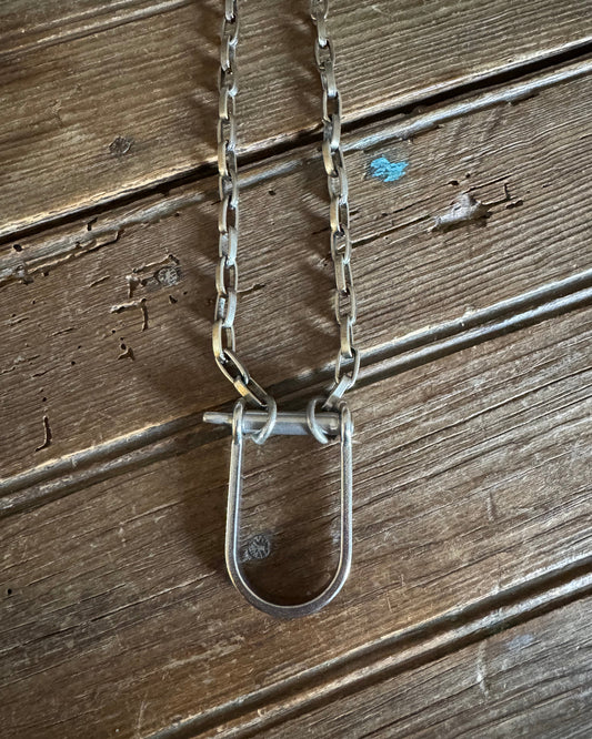 Silver necklace large shackle on rustic wood background