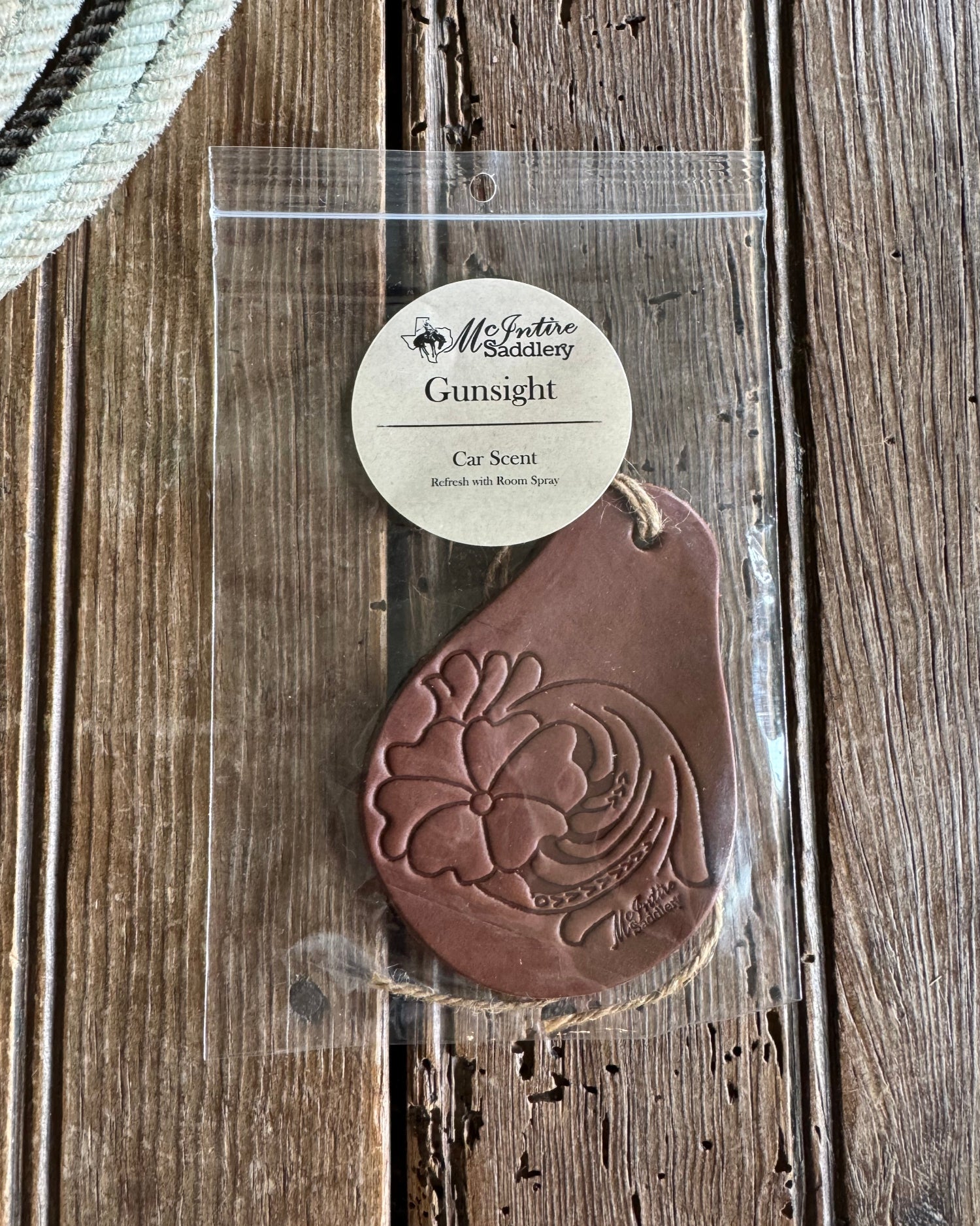 Brown leather car scent with floral design on a wooden surface
