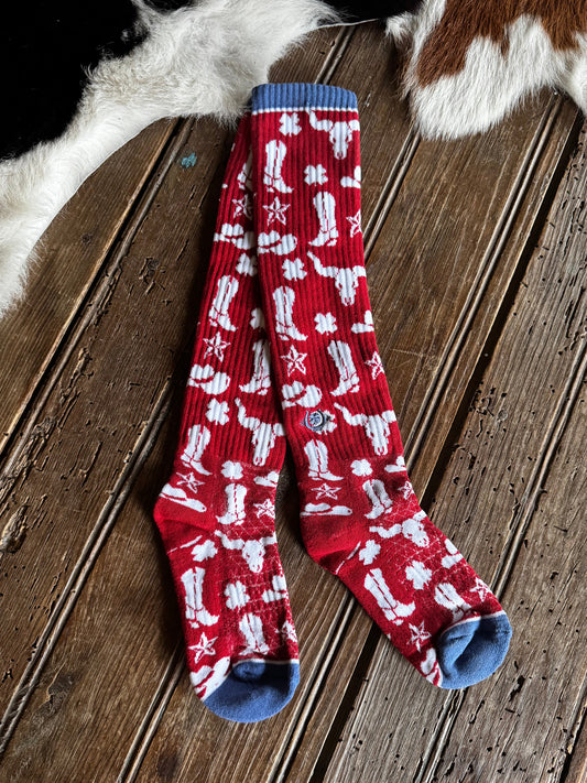 Red socks with white patterns on a wooden floor