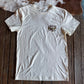 White t-shirt with a logo on a wooden surface with a cowhide rug in the background