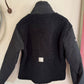 Black jacket with a textured back panel on a hanger against a light background