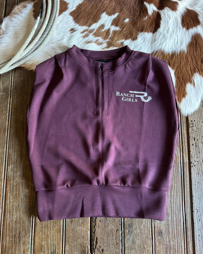 Purple shirt with 'Ranch Girls' logo on a wooden surface with cowhide rug