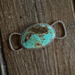 Turquoise stone twilly slide on a wooden surface