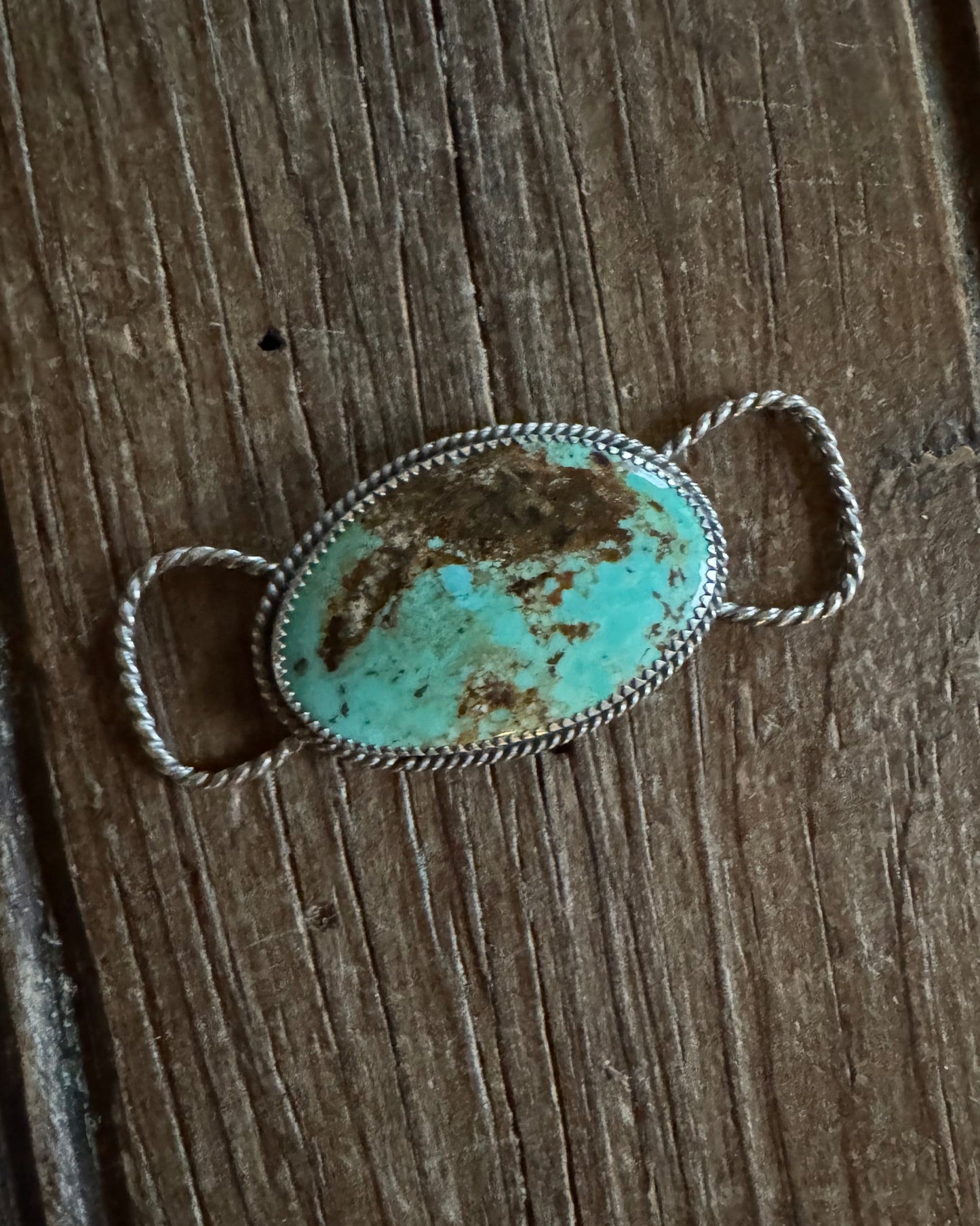 Turquoise stone twilly slide on a wooden surface