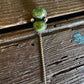Green stone earring on a wooden surface