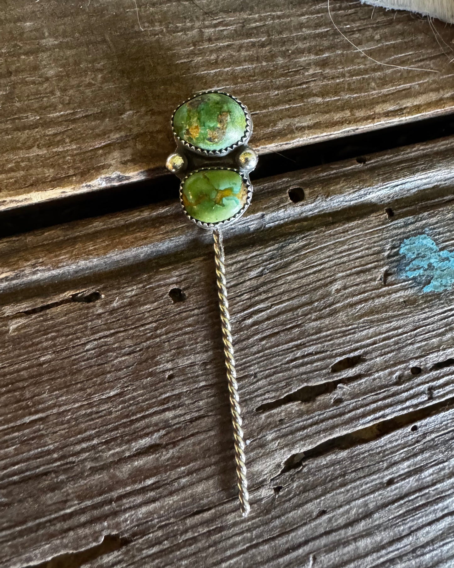 Green stone earring on a wooden surface