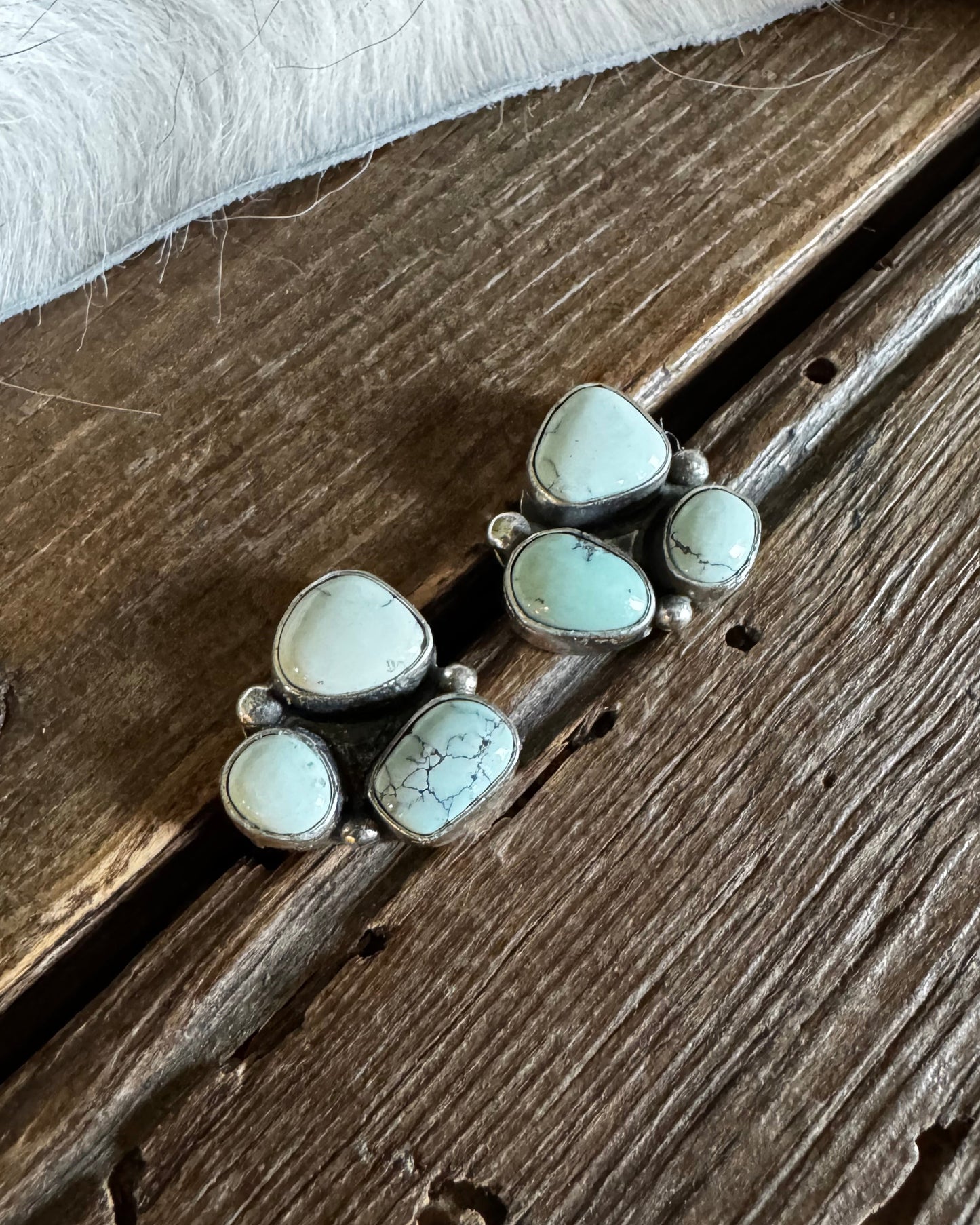 Silver earrings with white stones on a wooden surface