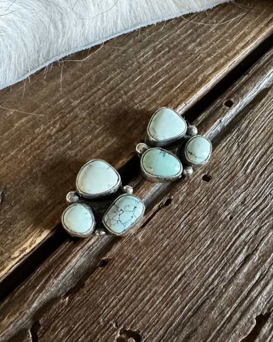 Silver earrings with white stones on a wooden surface