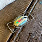 Jewelry with a colorful stone on a wooden surface
