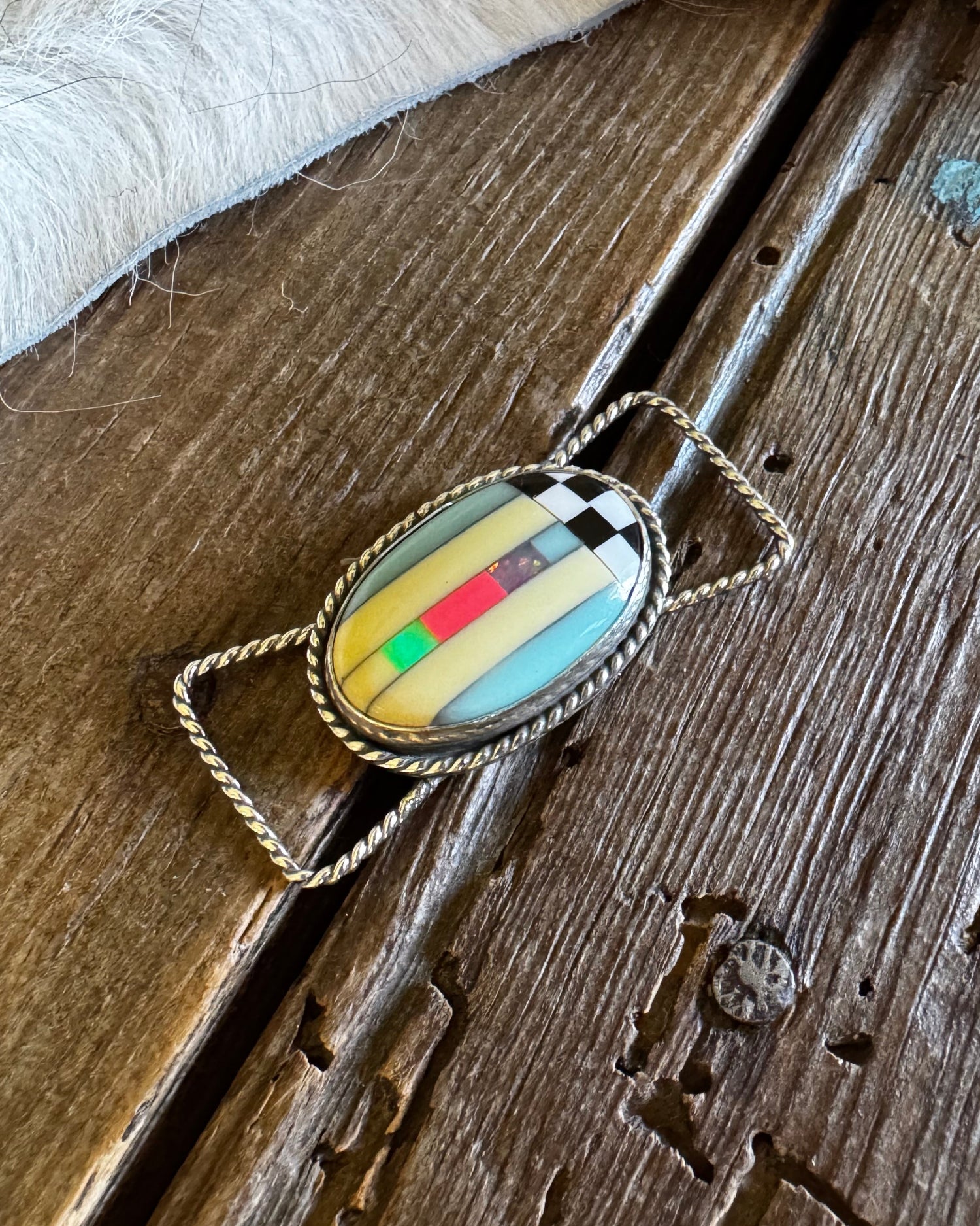 Jewelry with a colorful stone on a wooden surface