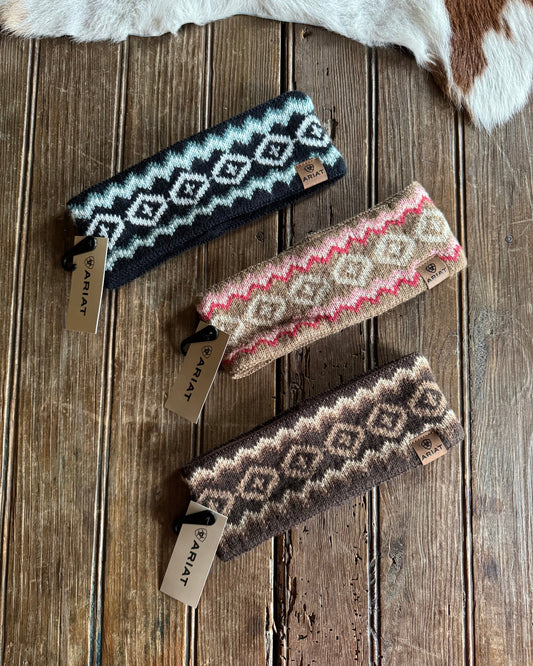 Three patterned headbands on a wooden surface with visible brand tags.
