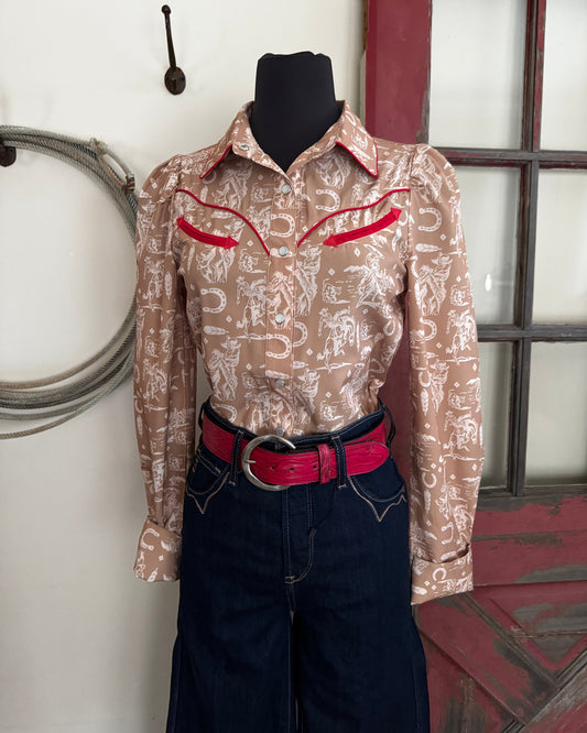 Patterned shirt with red accents on a stand against a white wall.