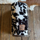 cow print blanket on a wooden surface with cowhide rug