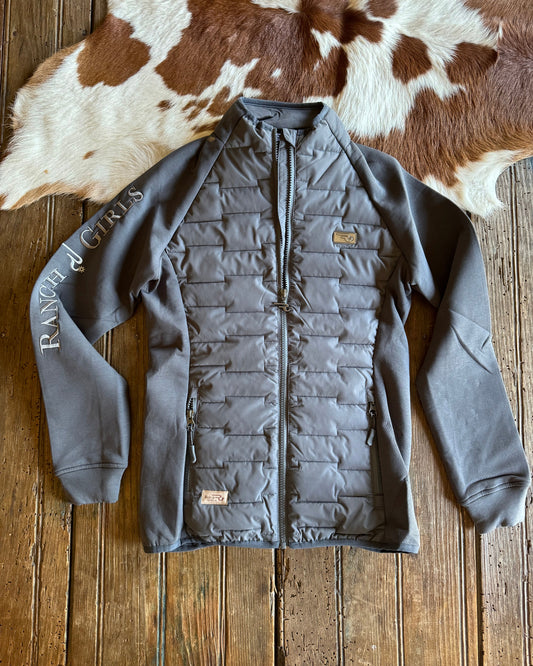 Gray quilted jacket on a wooden surface with cowhide rug