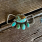 Turquoise stone brooch on a wooden surface