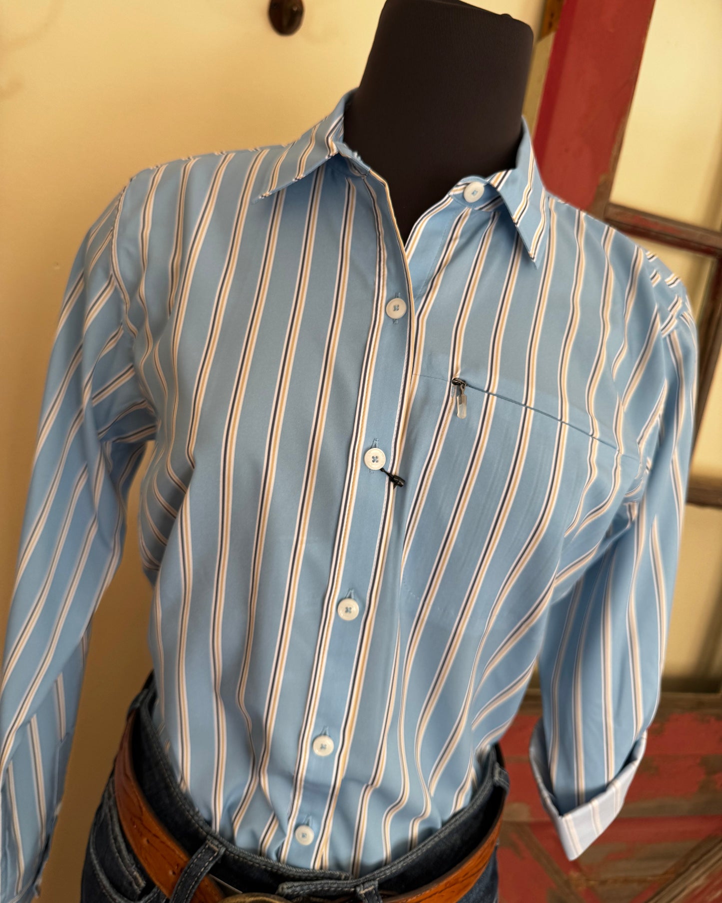 Blue and white striped shirt on a mannequin against a neutral background