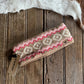 Knitted headband with a pattern on a wooden surface, Ariat tag visible