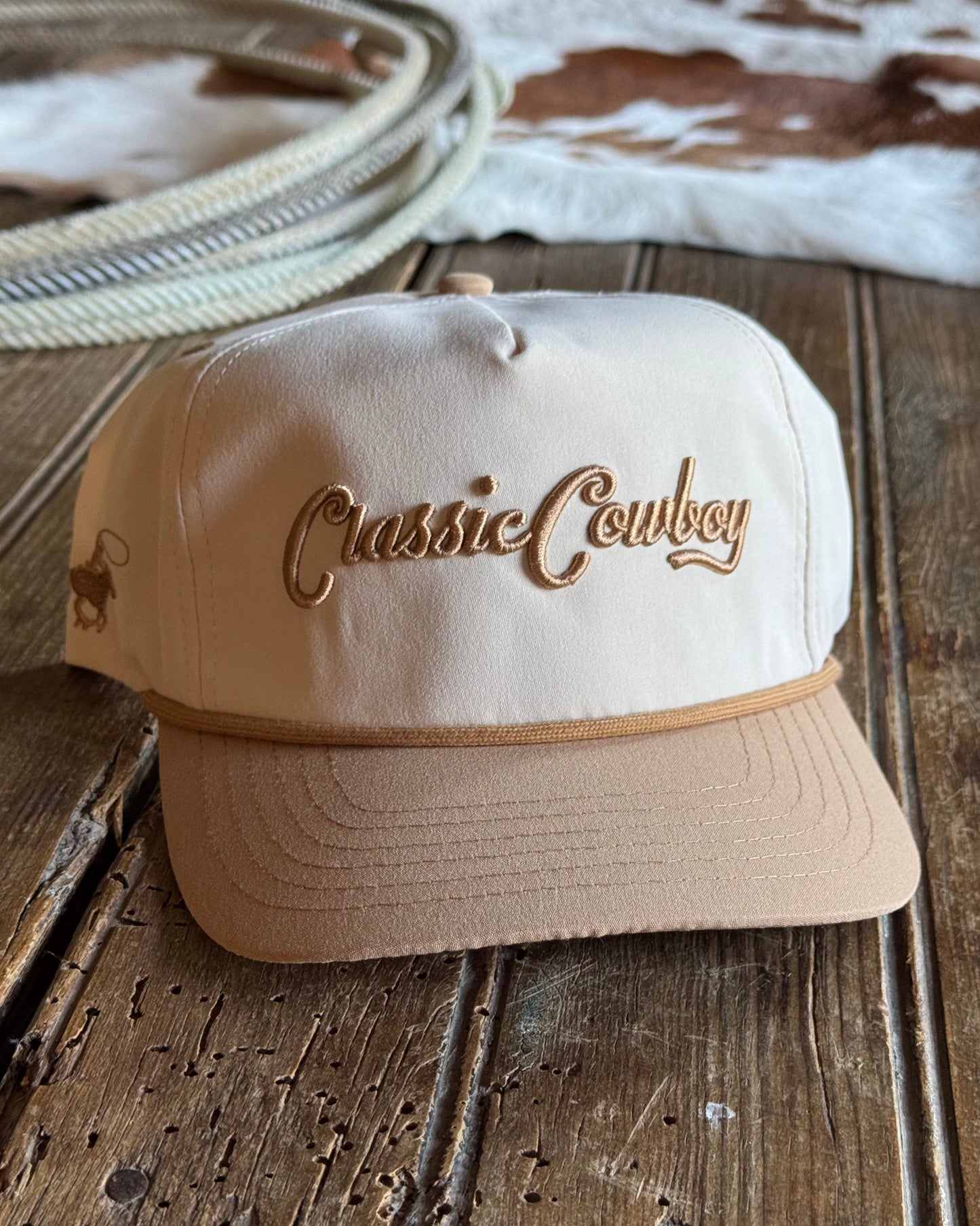 Beige cap with 'Classic Cowboy' logo on a wooden surface
