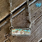 Royston Ribbon turquoise necklace on a rustic wooden background