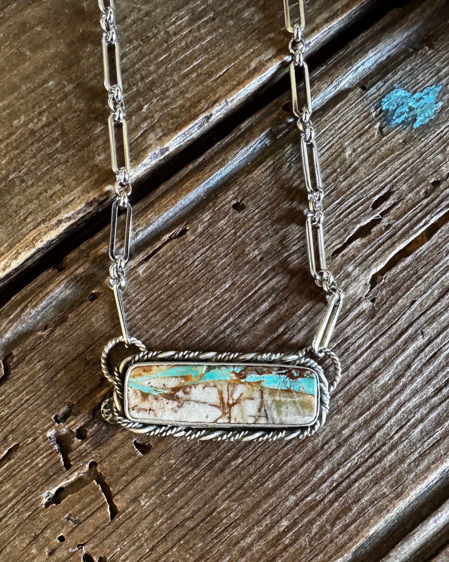 Royston Ribbon turquoise necklace on a rustic wooden background