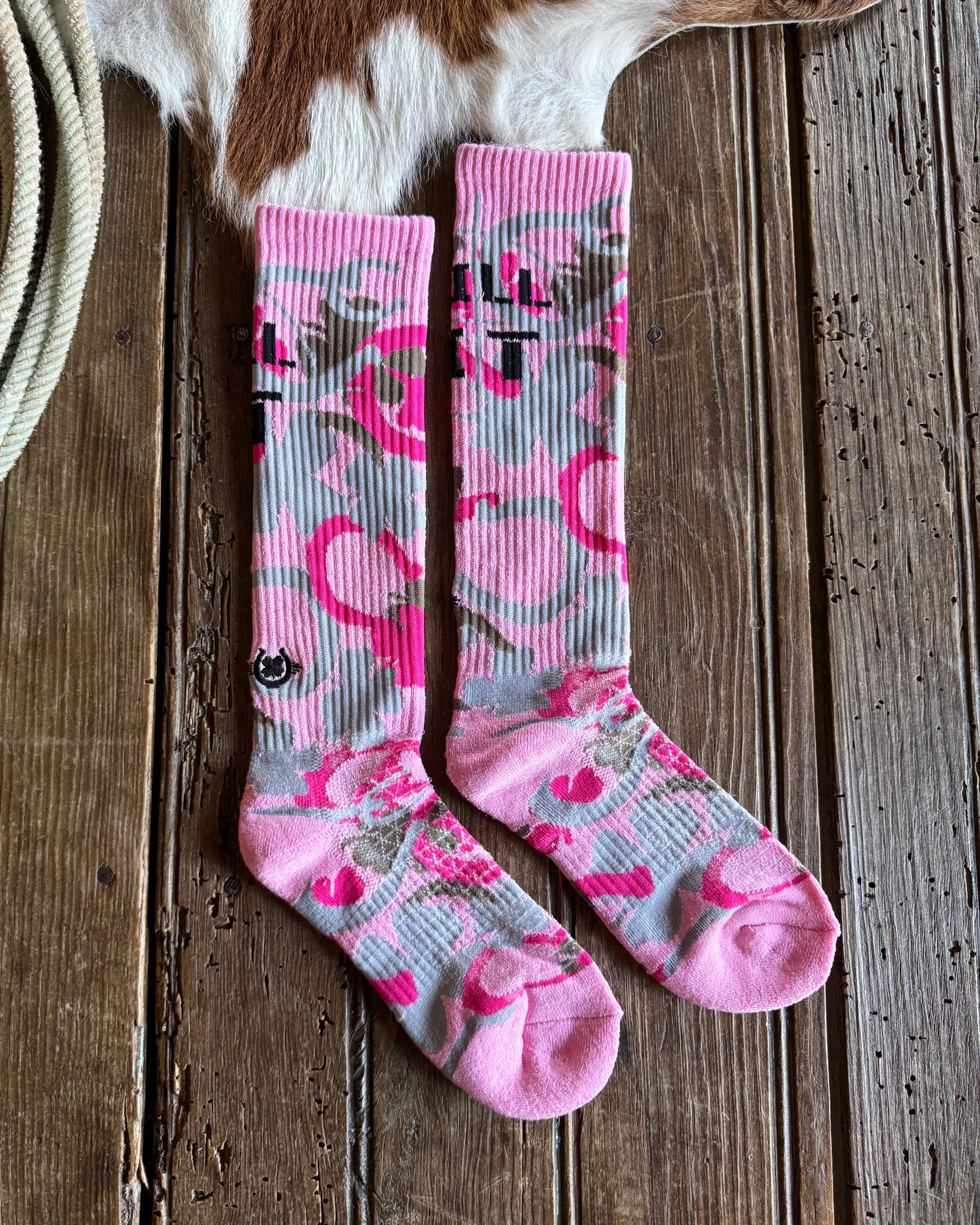 Pink and gray patterned socks on a wooden surface 
