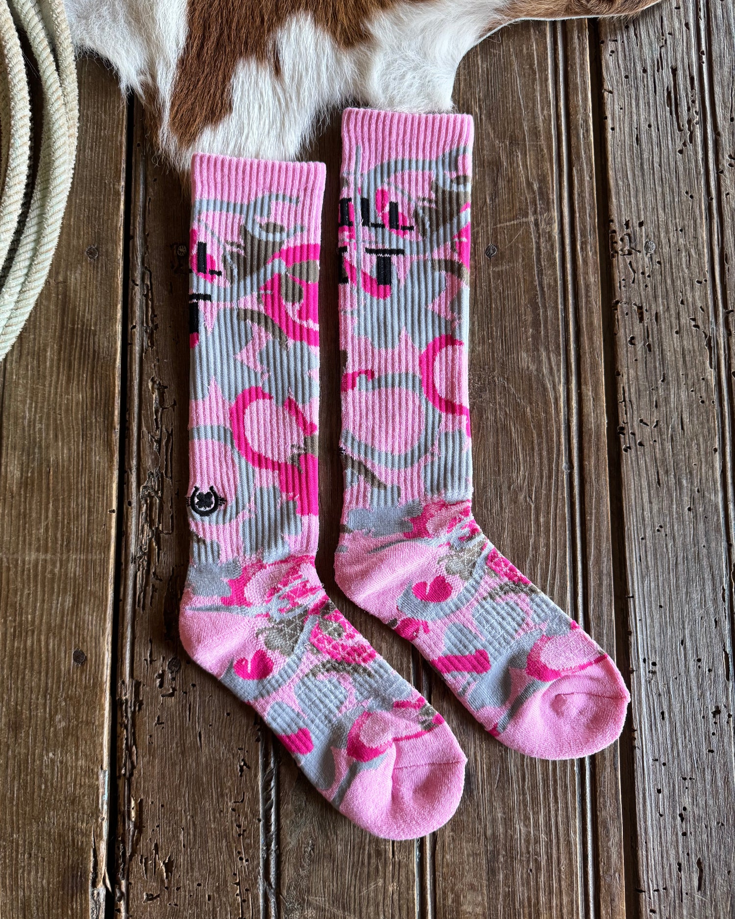 Pink and gray patterned socks on a wooden surface 