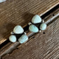 Silver earrings with white stones on a wooden surface