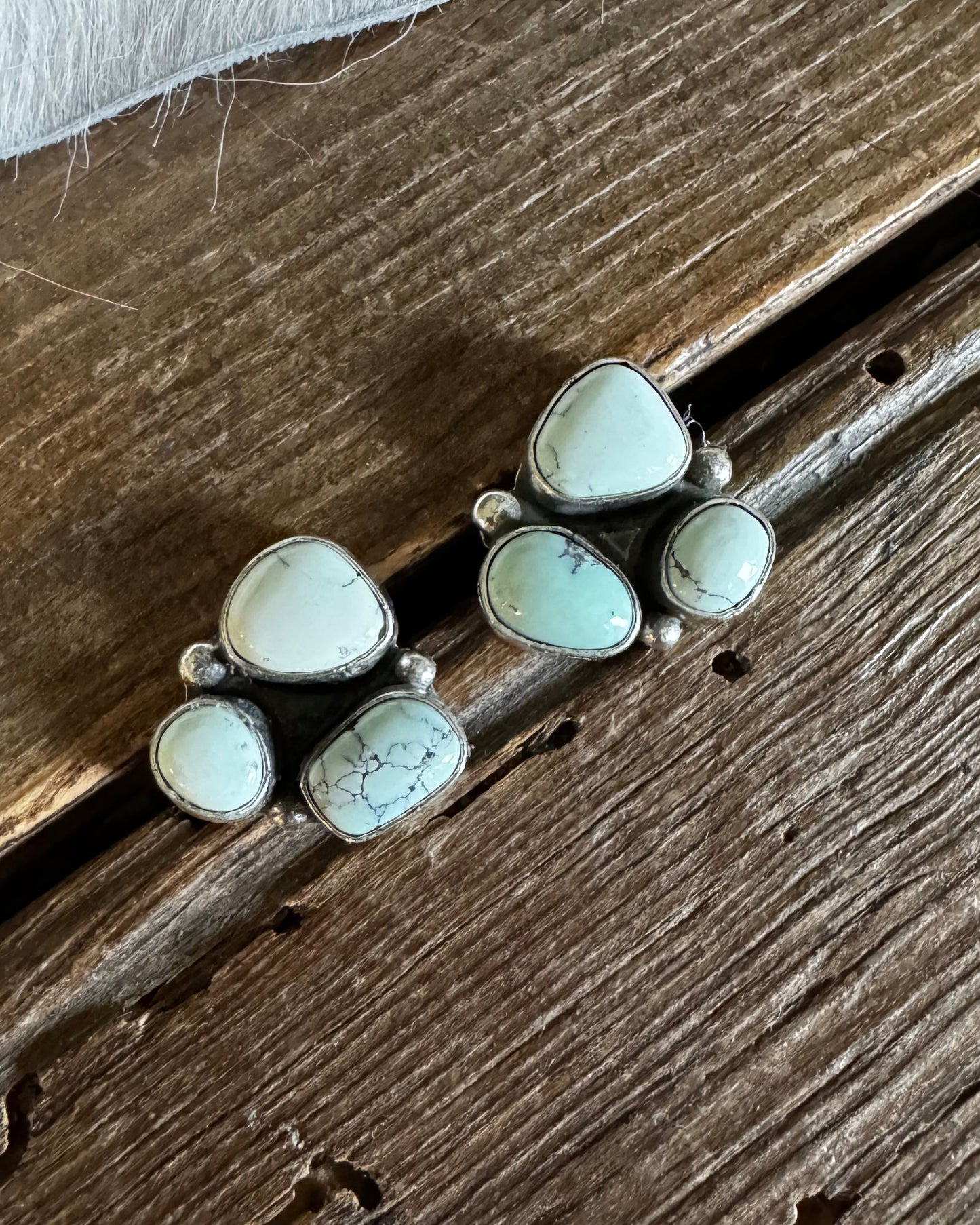 Silver earrings with white stones on a wooden surface