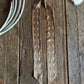 Ribbon scarf with white patterns on a wooden surface.