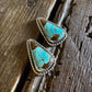 Turquoise stone earrings on a wooden surface