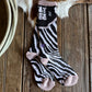 Zebra-patterned sock with a wooden background