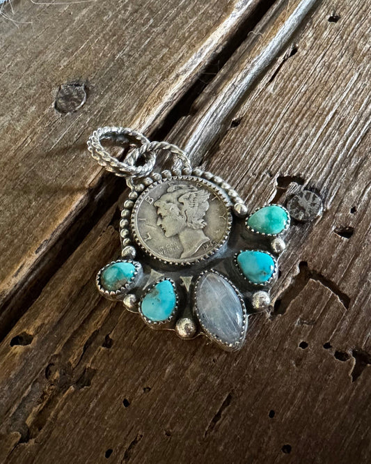 Pendant with coins and turquoise stones on a wooden surface