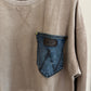 Beige sweatshirt with a denim pocket patch on a hanger