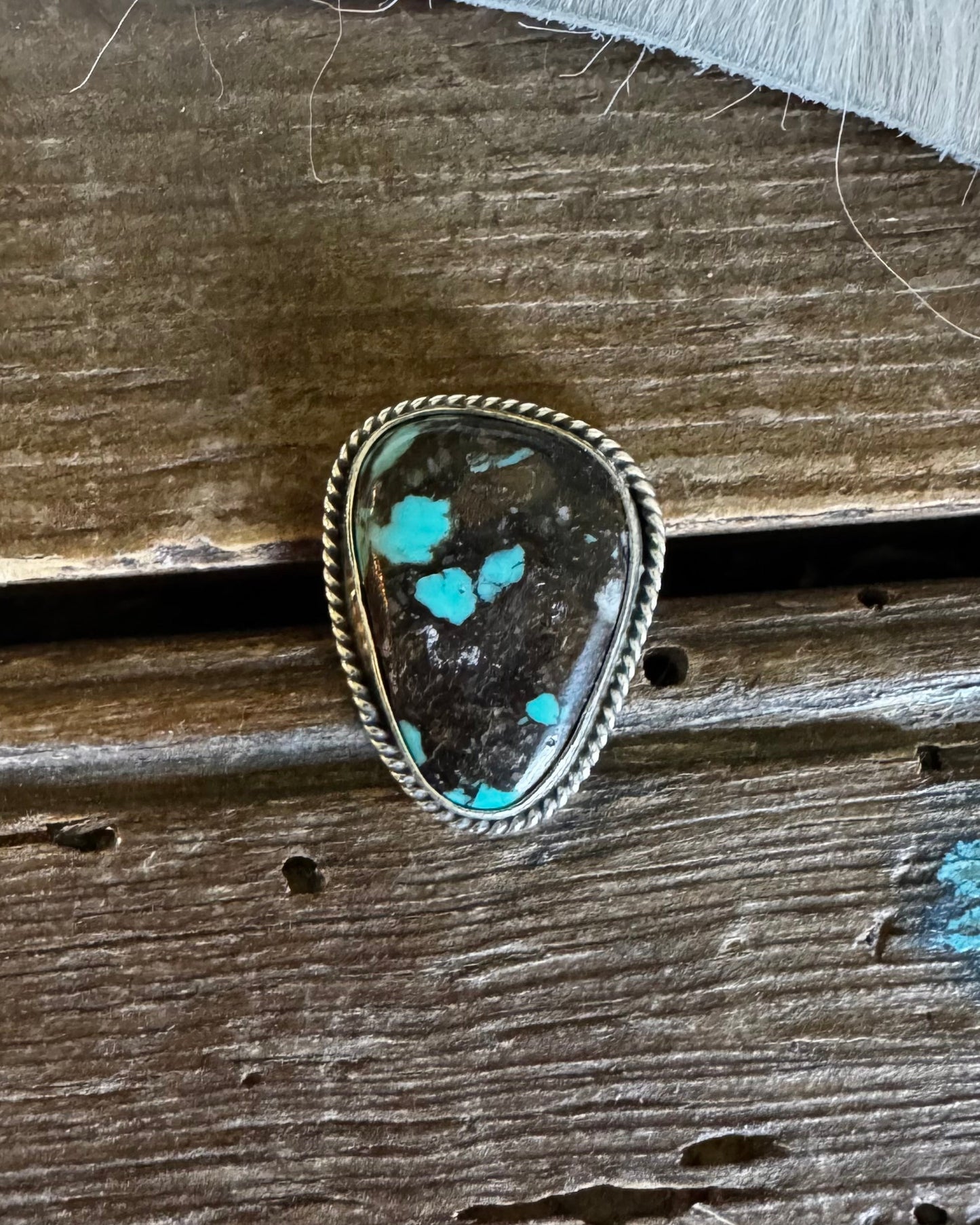 Turquoise scarf slide ring on a wooden surface