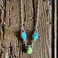 Necklace with turquoise and green beads on a wooden surface