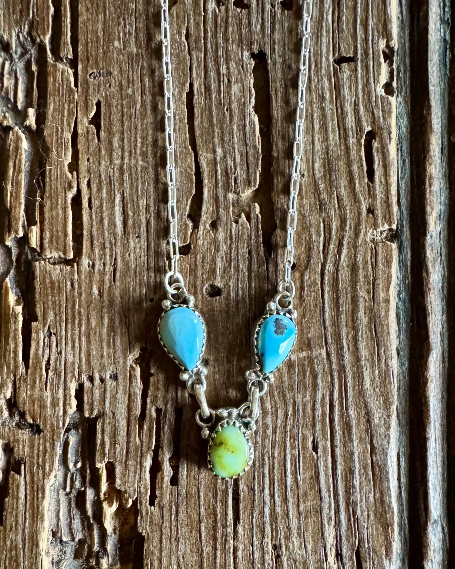 Necklace with turquoise and green beads on a wooden surface