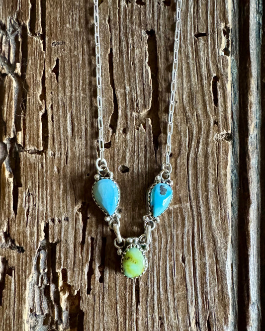 Necklace with turquoise and green beads on a wooden surface