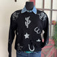 Black sweater with white patterns on a mannequin against a neutral background