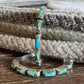 Turquoise inlay silver earrings on a textured surface