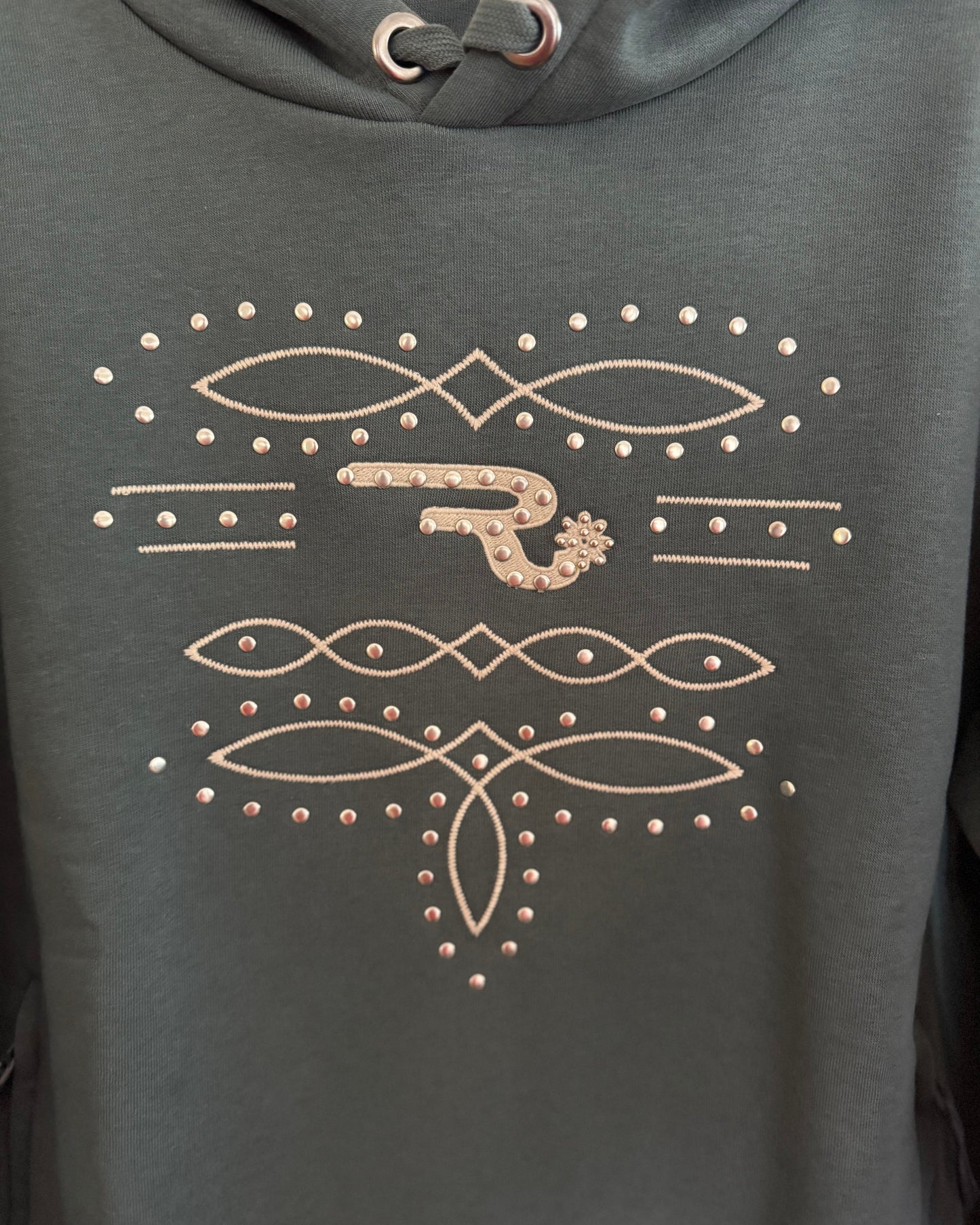 Dark gray hoodie with decorative gold patterns and embellishments.