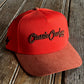Orange cap with 'Classic Cowboy' logo on a wooden surface