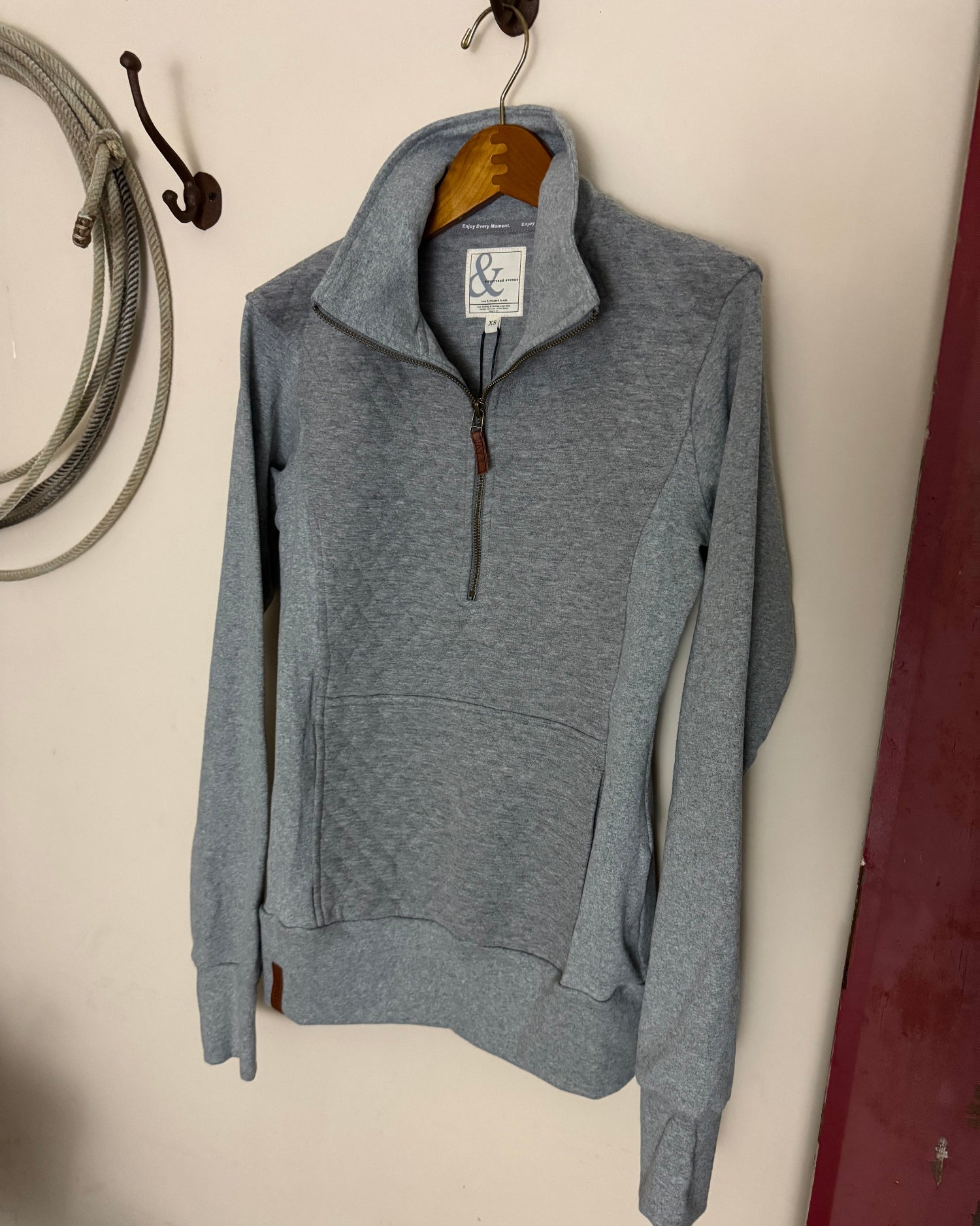 Gray hoodie with a brand tag on a light-colored surface