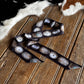 Decorative ribbon with circular patterns on a wooden surface next to a cowhide rug