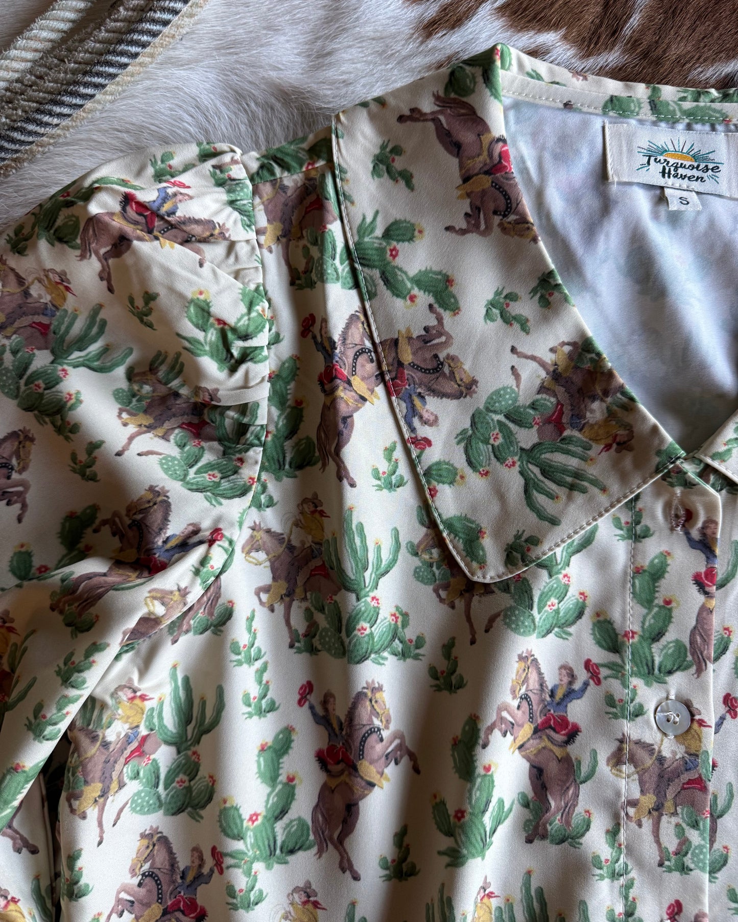 Fabric with cowboy and cactus pattern on a white background