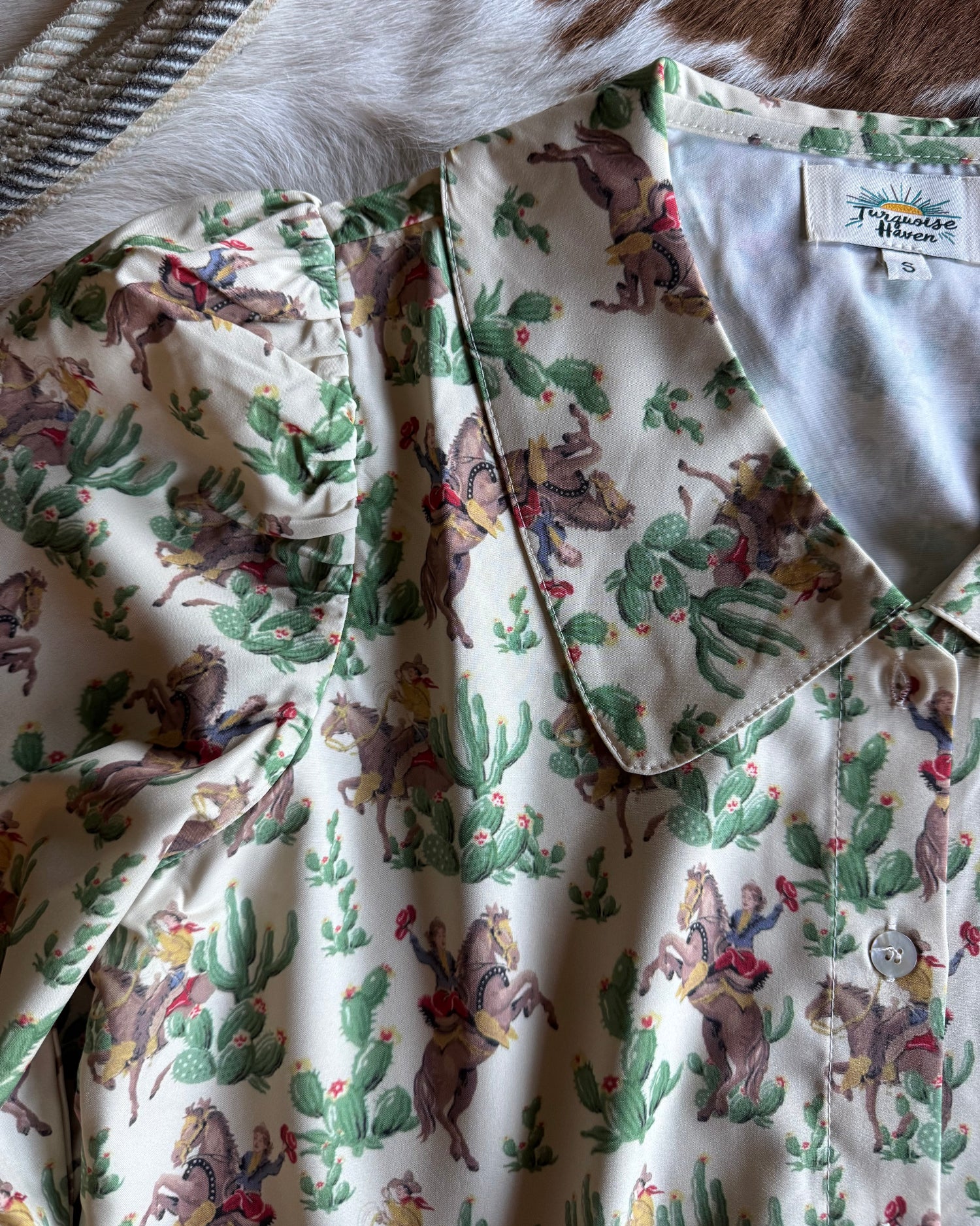 Fabric with cowboy and cactus pattern on a white background