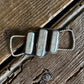 Silver twilly slide with rope design on a wooden surface