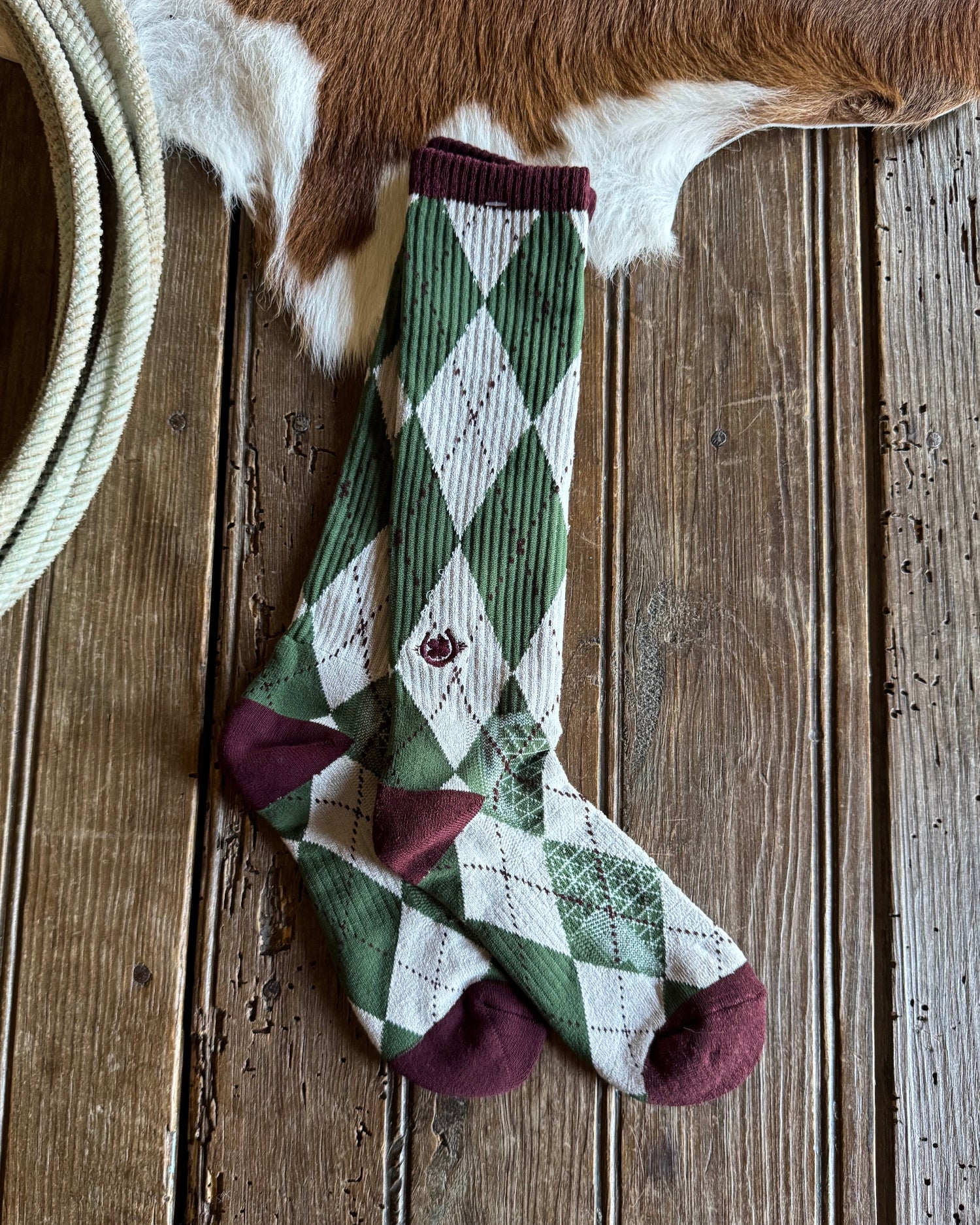 Plaid socks on a wooden surface with a cowhide in the background